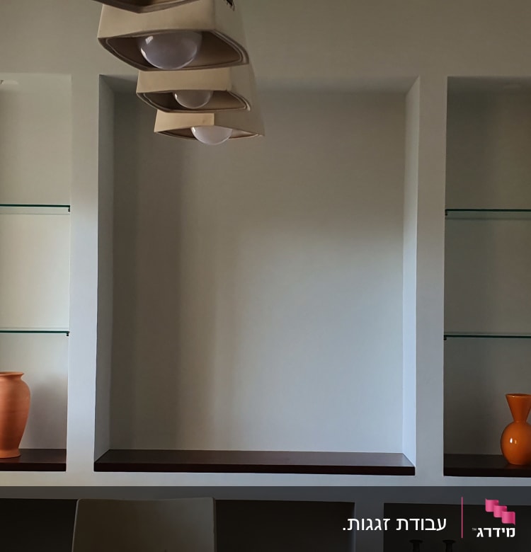 מדפי זכוכית שקופים בתוך נישה בקיר